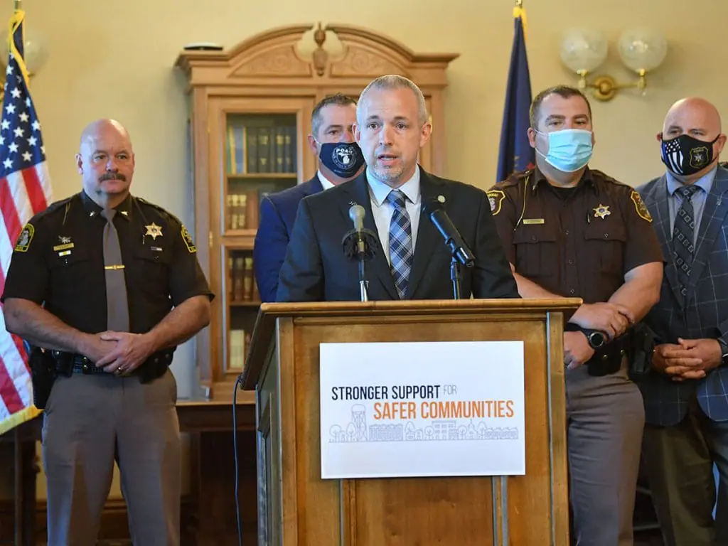 Michigan Speaker of The House Jason Wentworth speaking at a press conference with various law enforcement department heads standing behind him. | Training Plan to Support Local Police