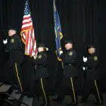 Police Officer holding flags climb steps to the POAM Annual Convention 2009 stage