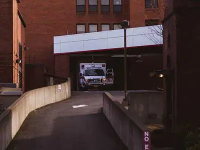 Emergency ambulance in the bay entrance of a hospital | Front Line First Responders | Executive Order 2020-153