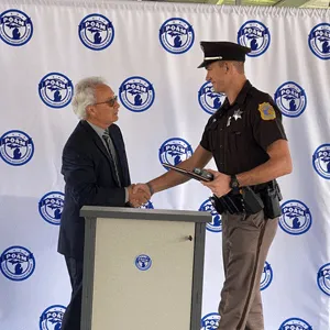 Deputy Noah Susick, Kalamazoo County Sheriff's Department shaking the hand of POAM President Tignanelli