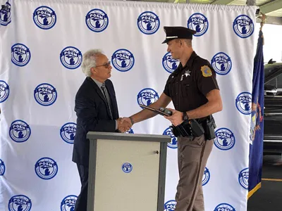 Deputy Noah Susick, Kalamazoo County Sheriff's Department shaking the hand of POAM President Tignanelli