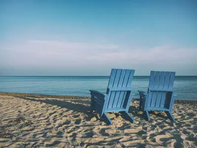 Two empty chair on the beach, facing the ocean. | Retirement With Adult Children | Lifestyle Choices | Medicare and Retirement