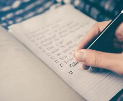 Person writing to do list on paper | Financial To Do List | Beneficiary Information