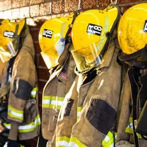 Firefighter uniforms hanging on a wall