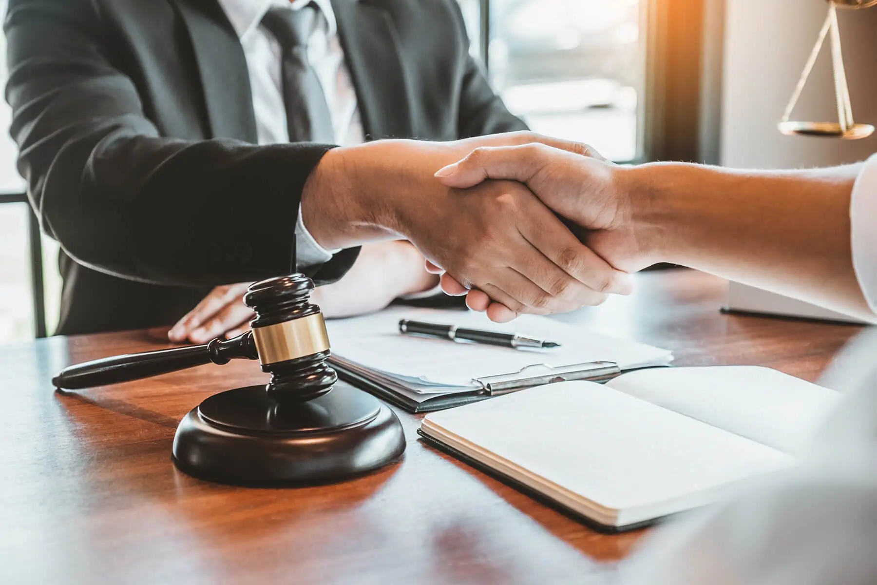 Men shaking hands over a table with papers laying on the table. | Public Act 312