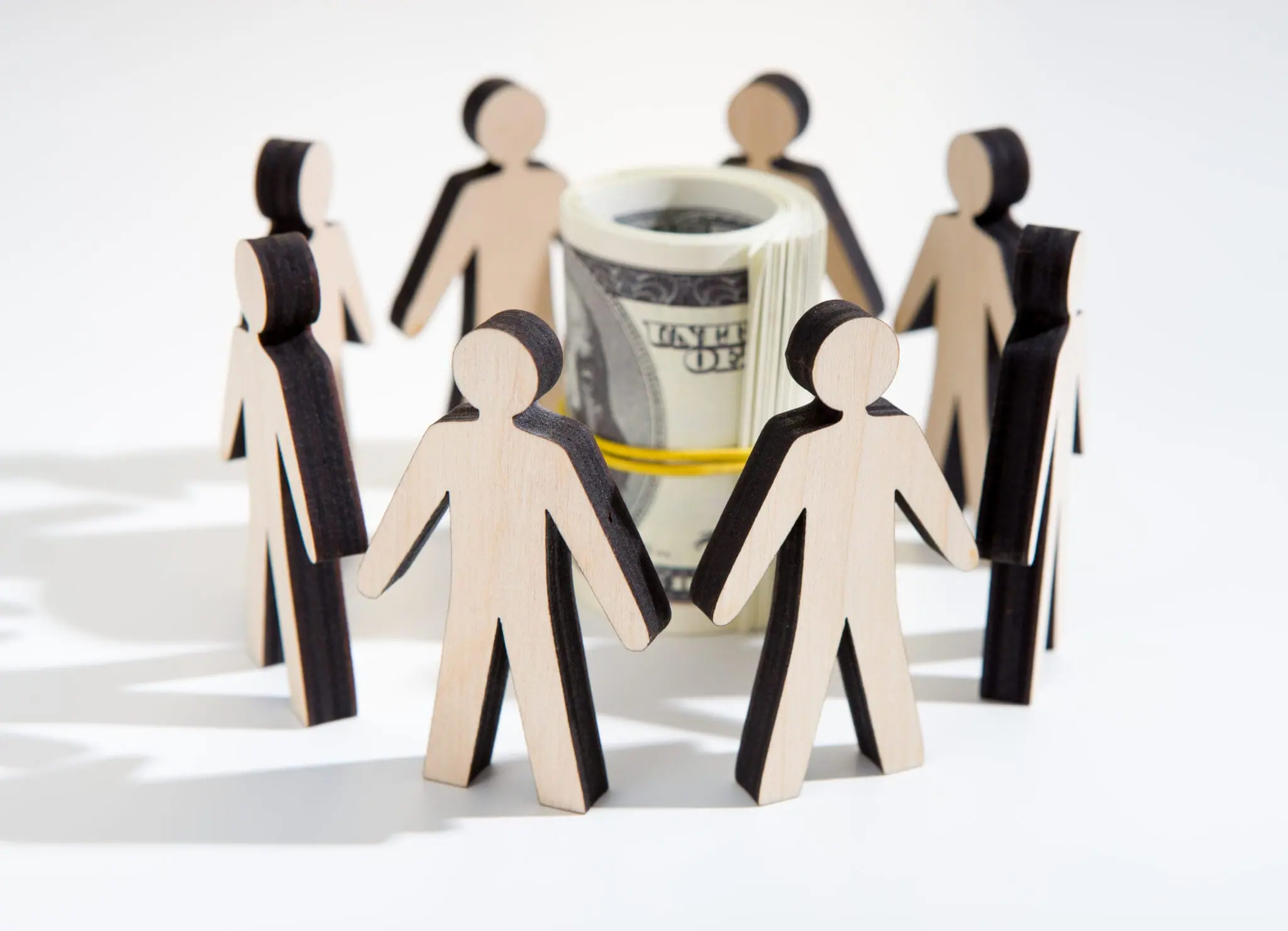 Cardboard figure standing in a cirle with a roll of money inside |Investing for Impact