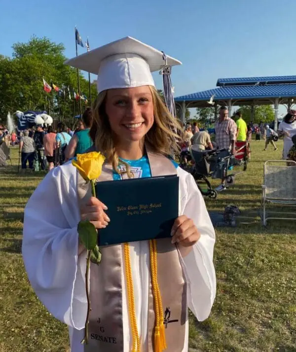 POAM Scholarship Recipient Kami Box holding her high school diploma.
