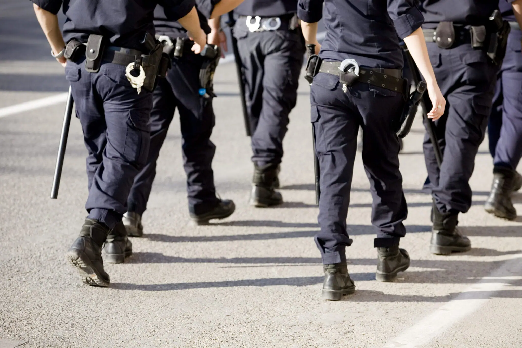 The legs of five police officers in uniform walking | Law enforcement union representation | Public Safety Hiring Event