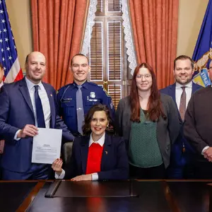 Senator Kevin Hertel, POAM Legislative Director Kenneth E. Grabowski, and others during the ceremonial Senate 834 bill signing with Governor Gretchen Whitmer.