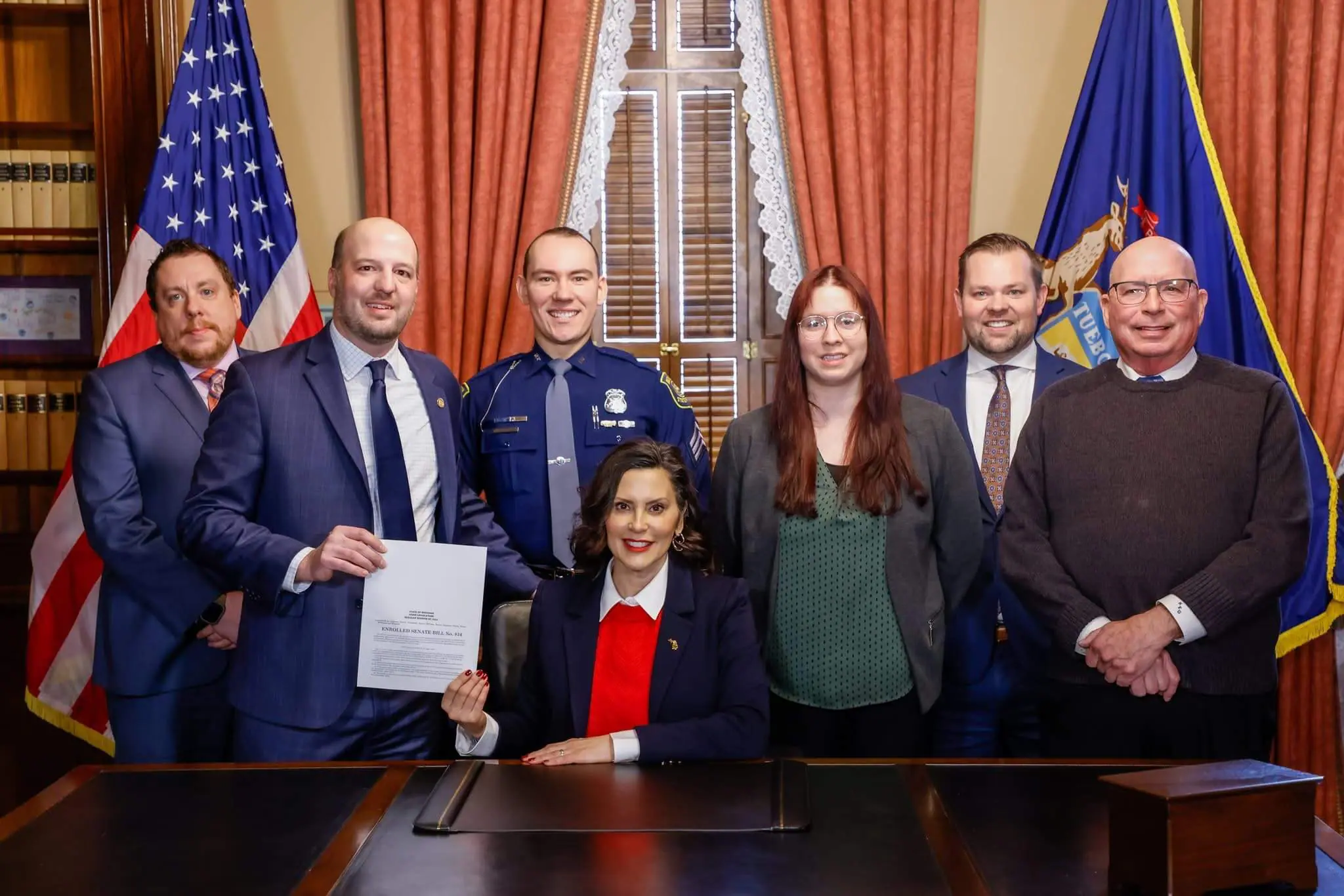 Senator Kevin Hertel, POAM Legislative Director Kenneth E. Grabowski, and others during the ceremonial Senate 834 bill signing with Governor Gretchen Whitmer.